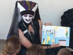 Sister Rita Booke reading Dr. Seuss's Horse Museum to children outside the Chula Vista Public Library during Drag Queen Story Time.